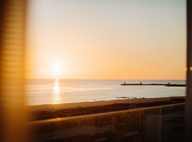 Vista do pôr do sol sobre o mar da varanda do hotel